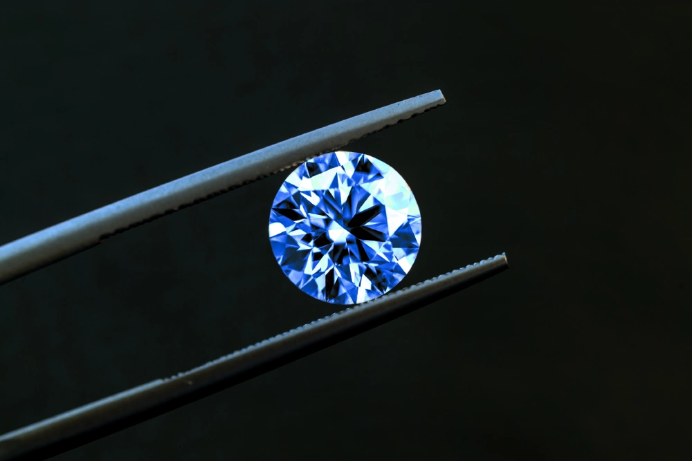 piedra azul cogida entre dos pinzas
